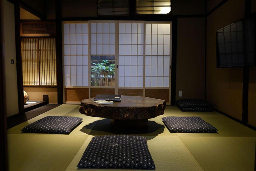 um quarto com uma mesa e dois tapetes no chão em Reikaku Kiyomizu Gojo em Quioto