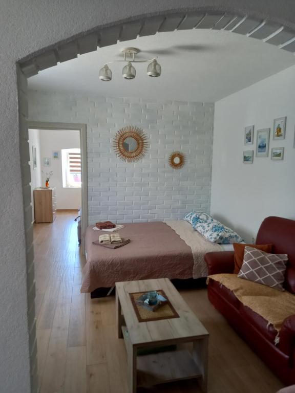 a bedroom with a bed and a couch and a table at Old marine house in Tivat
