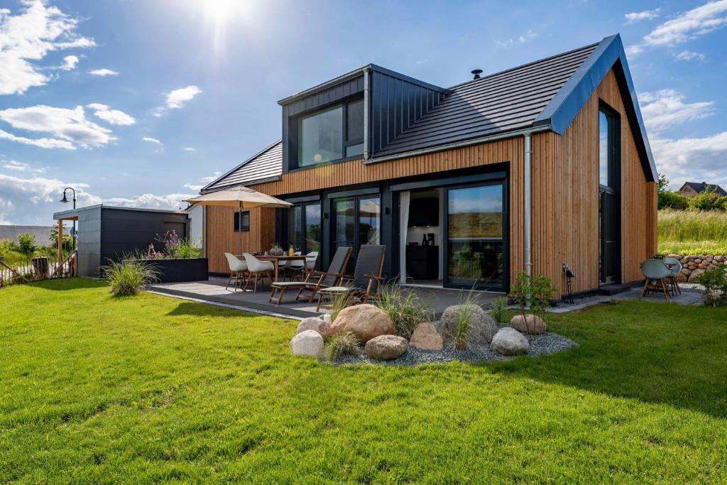 una casa con puertas de cristal y césped en Strandgaenger-Hohwacht en Hohwacht