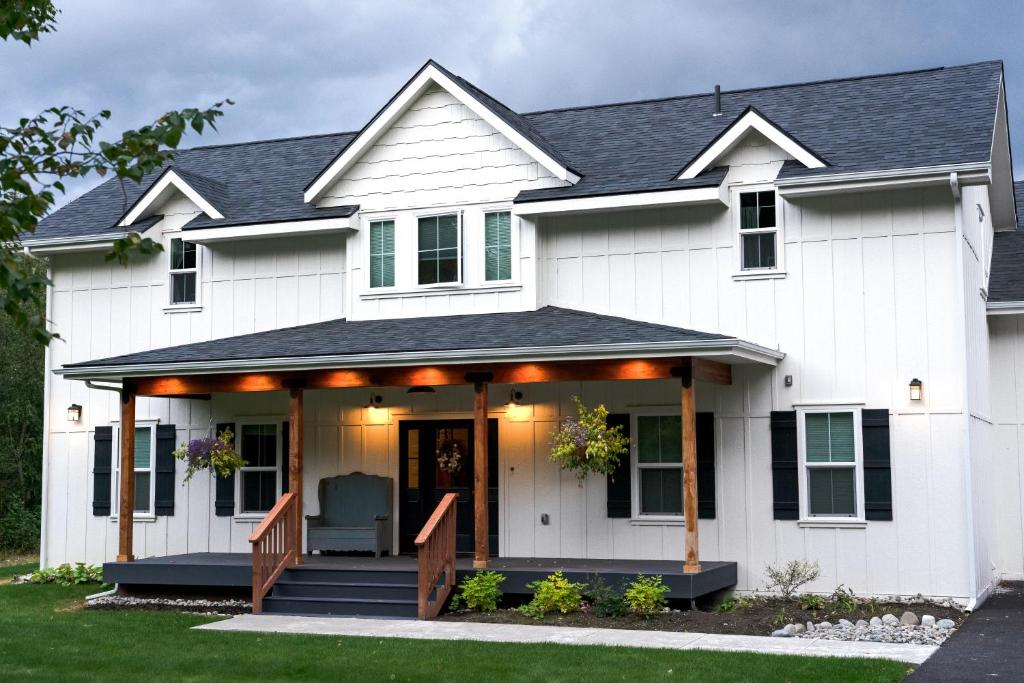 uma casa branca com um alpendre frontal com um deque em Snowgoose Pond Bed & Breakfast em Palmer