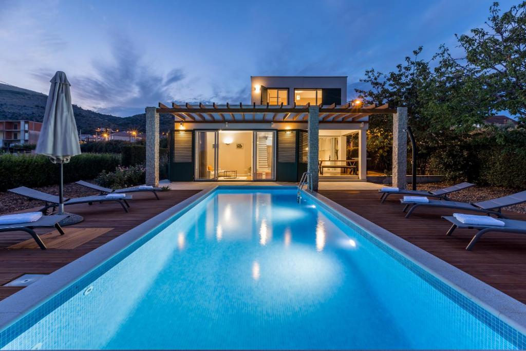 a swimming pool in front of a house at Villa Trogir save 15 percent on Split-villas com in Trogir