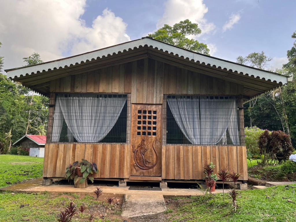 a small wooden house with a large door at El Zota Hotel in Cariari