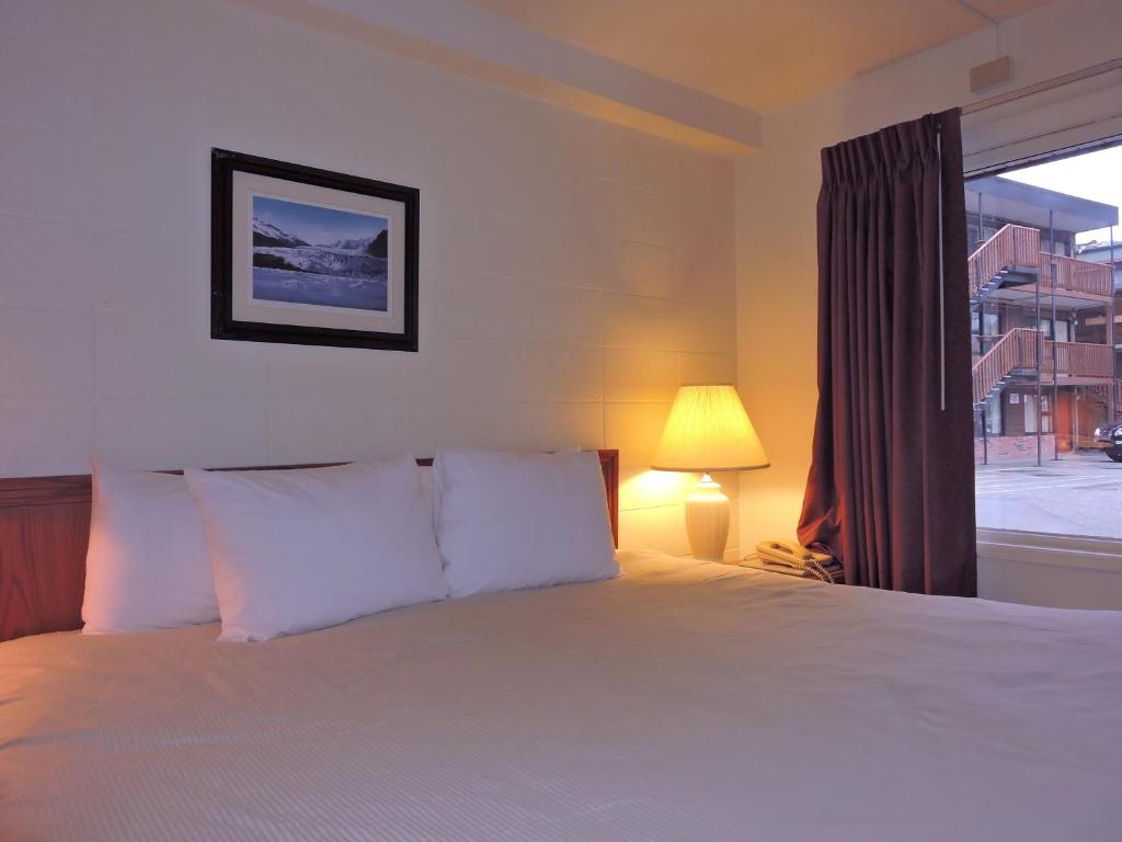 Un dormitorio con una cama grande y una ventana en The Driftwood Lodge en Juneau