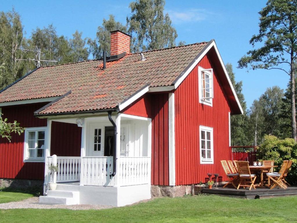 Casa roja y blanca con mesa en 6 person holiday home in GLANSHAMMAR, en Glanshammar