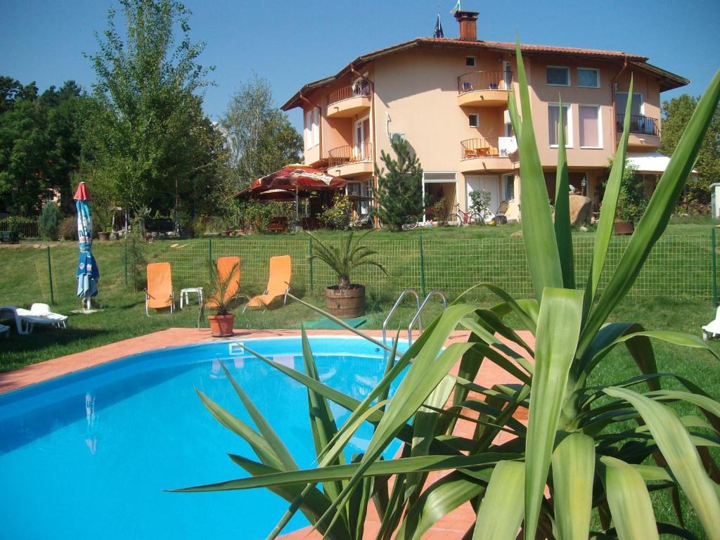 a villa with a swimming pool in front of a house at Sveti Georgi Family Hotel in Varshets