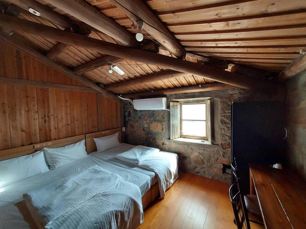sypialnia z łóżkiem w pokoju z drewnianym sufitem w obiekcie Quinbi Ocean View B&B w Beigan
