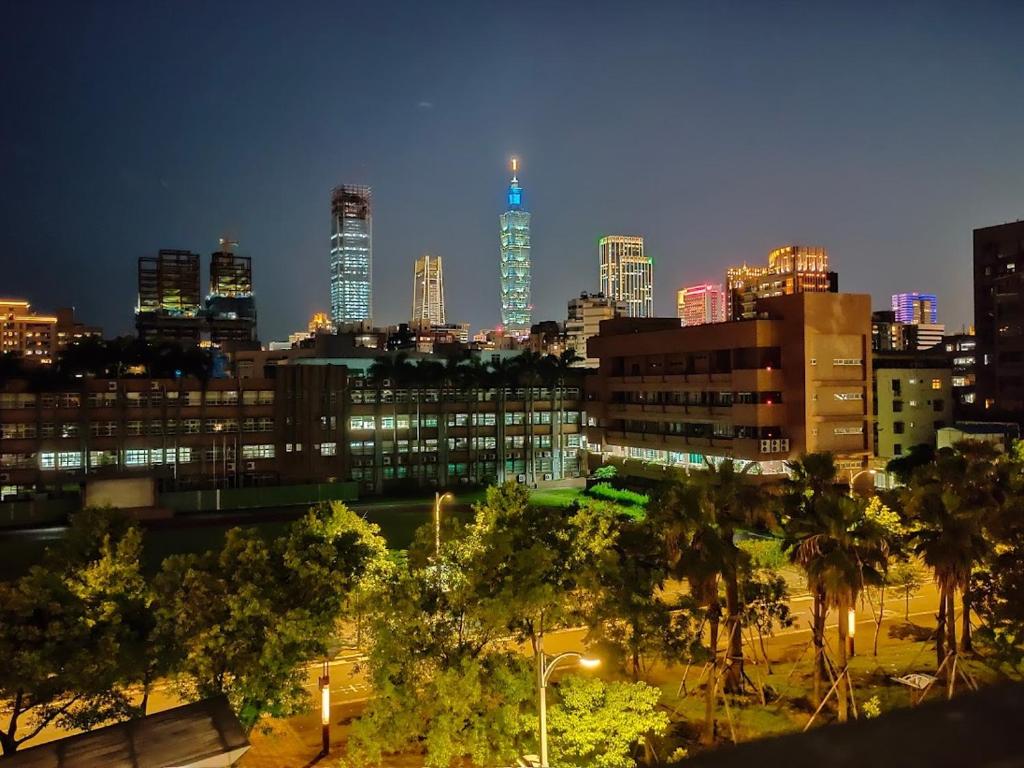 a city skyline at night with tall buildings at Showart Hotel in Taipei