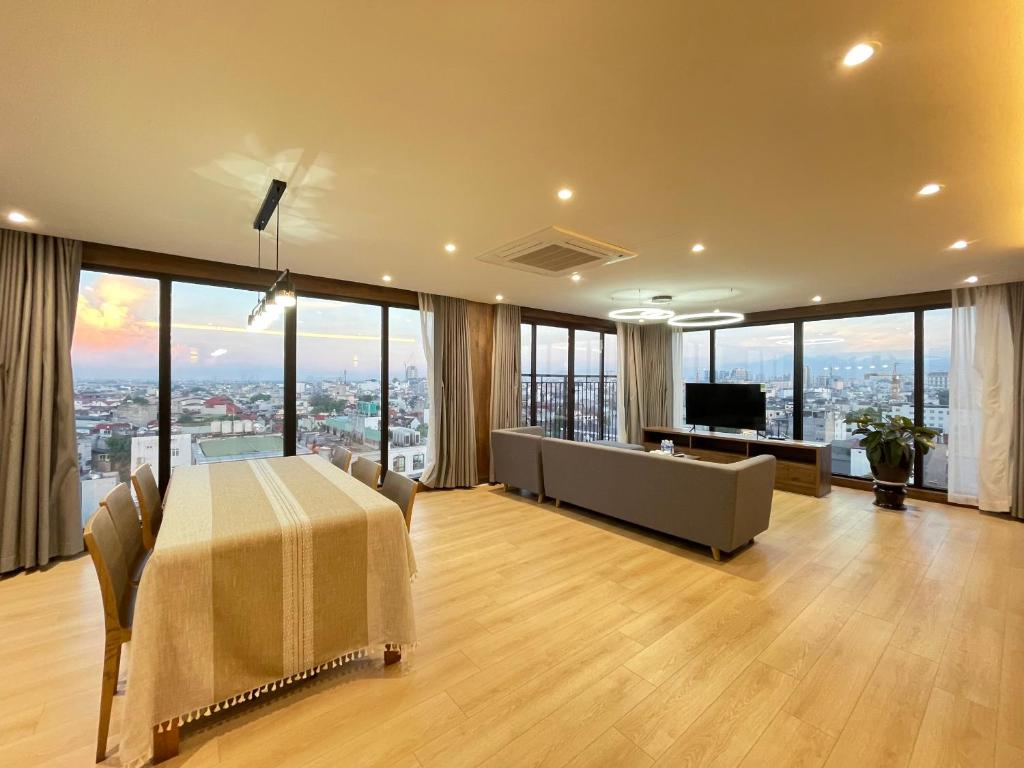 a large living room with a table and a couch at Ficus Suites in Hanoi