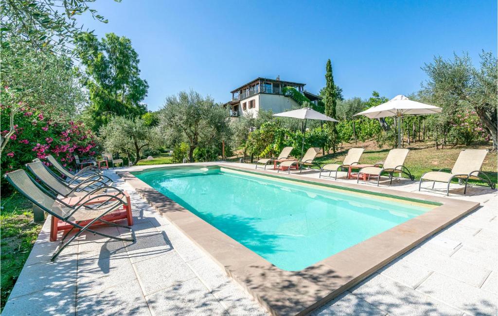 a swimming pool with chairs and umbrellas at Villa Luca in Vitorchiano