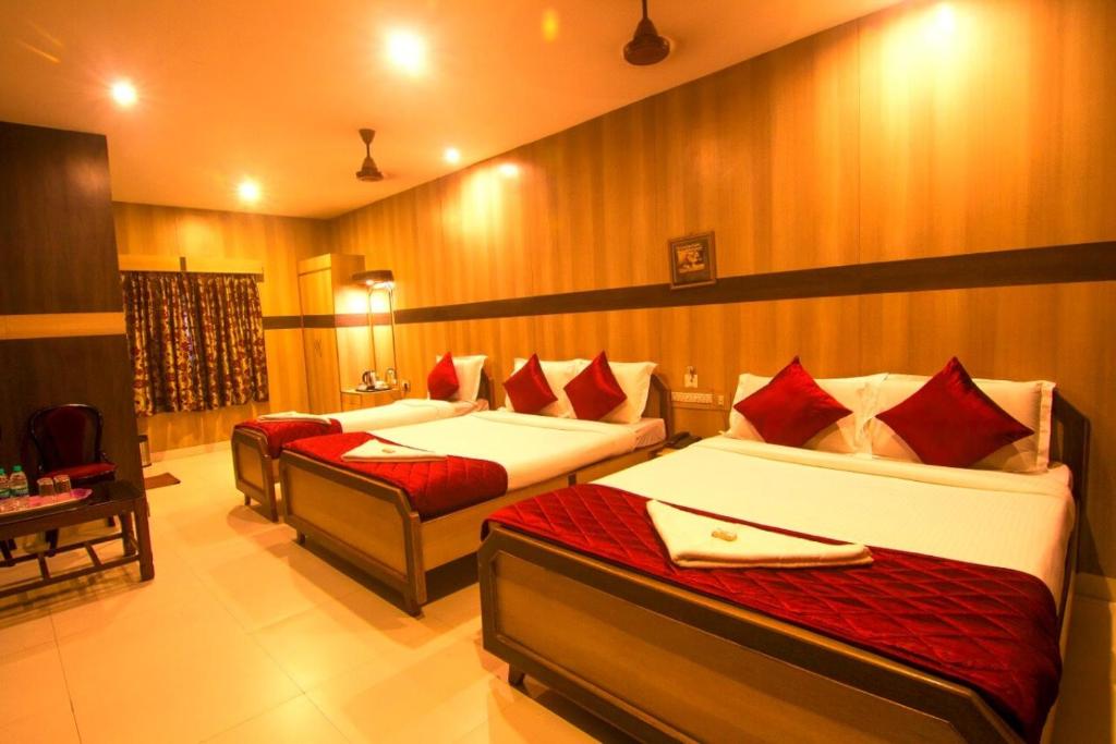 a room with two beds with red pillows at Jjs PARK INN in Chennai