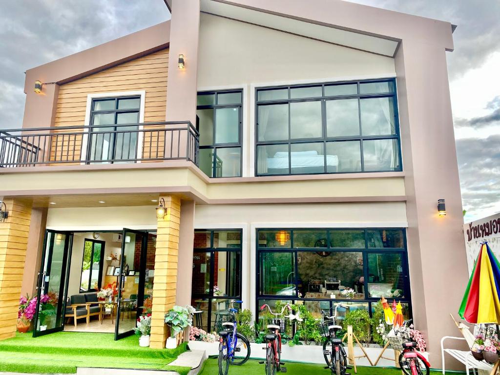 ein Haus mit Fahrrädern, die draußen geparkt sind in der Unterkunft โรงแรมบ้านหมอบิวแก่งคุดคู้ in Chiang Khan
