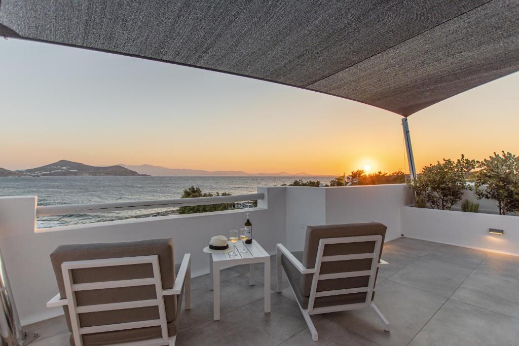 a balcony with a table and chairs and a view of the ocean at Galini Hotel in Naxos Chora