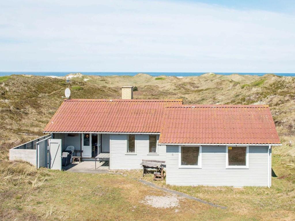 a white house with an orange roof on a hill at 6 person holiday home in Henne in Henne Strand