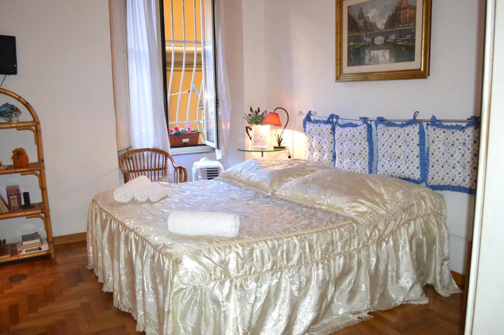 ein Schlafzimmer mit einem Bett mit einer weißen Tagesdecke in der Unterkunft Daffodil in Roma San Pietro in Rom