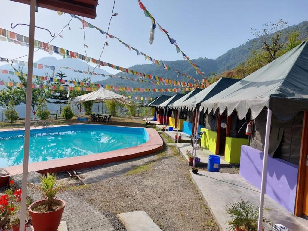 a resort with a swimming pool and some tents at Mussoorie Camp Resort in Mussoorie