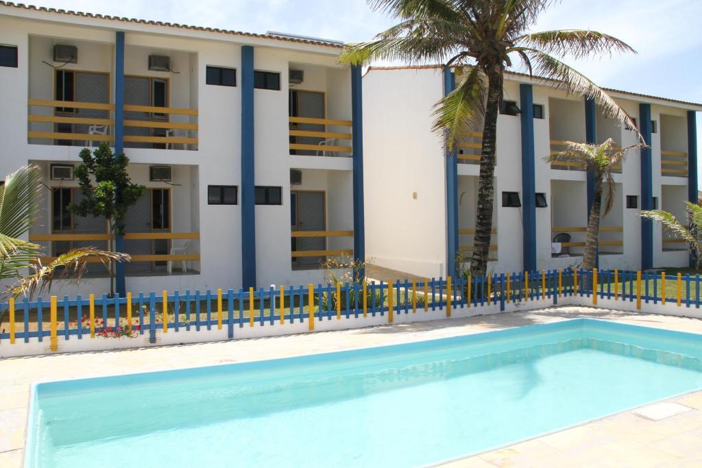 a building with a swimming pool in front of a building at Pousada Solar das Flores in Conceição da Barra