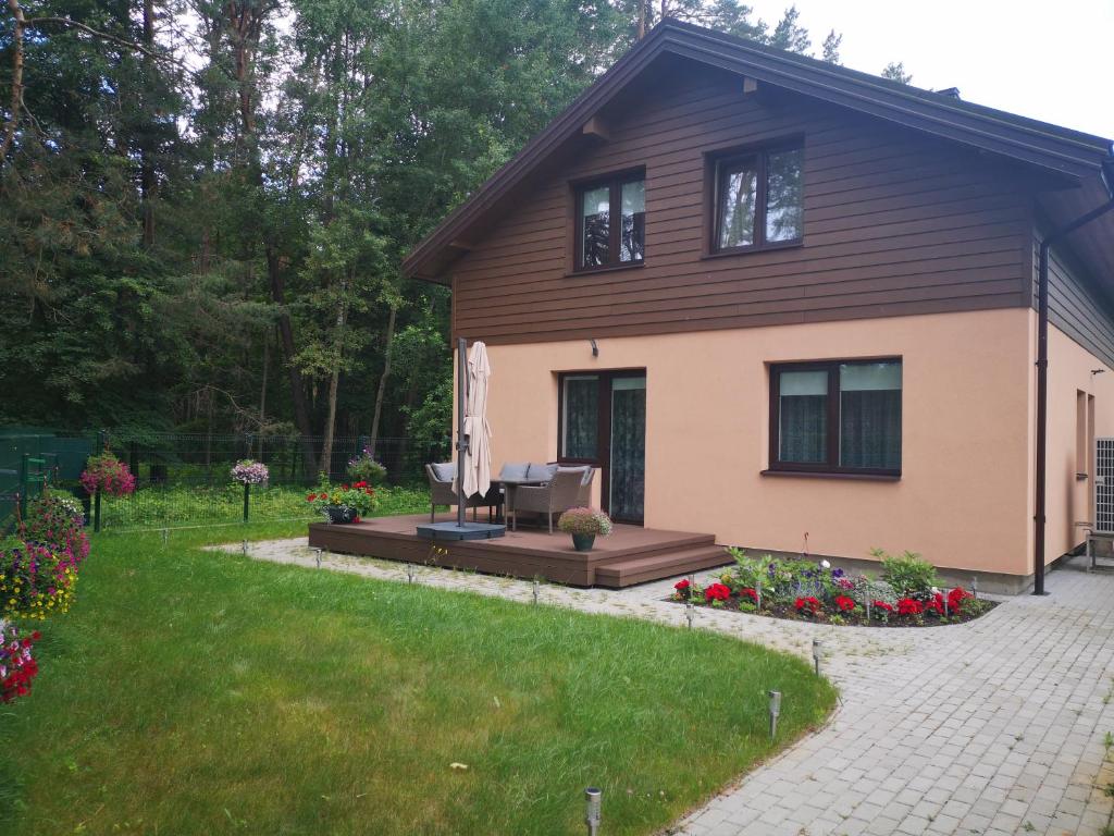 a house with a patio and flowers in the yard at Kristinos apartment in Druskininkai