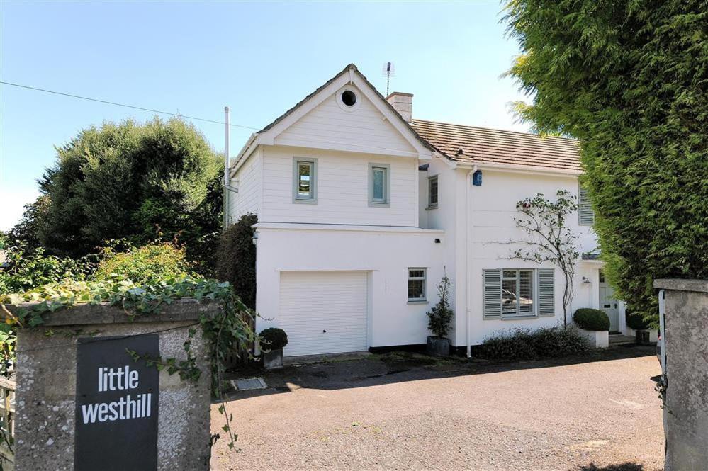 a white house with a garage and a driveway at Little West Hill Studio in Lyme Regis