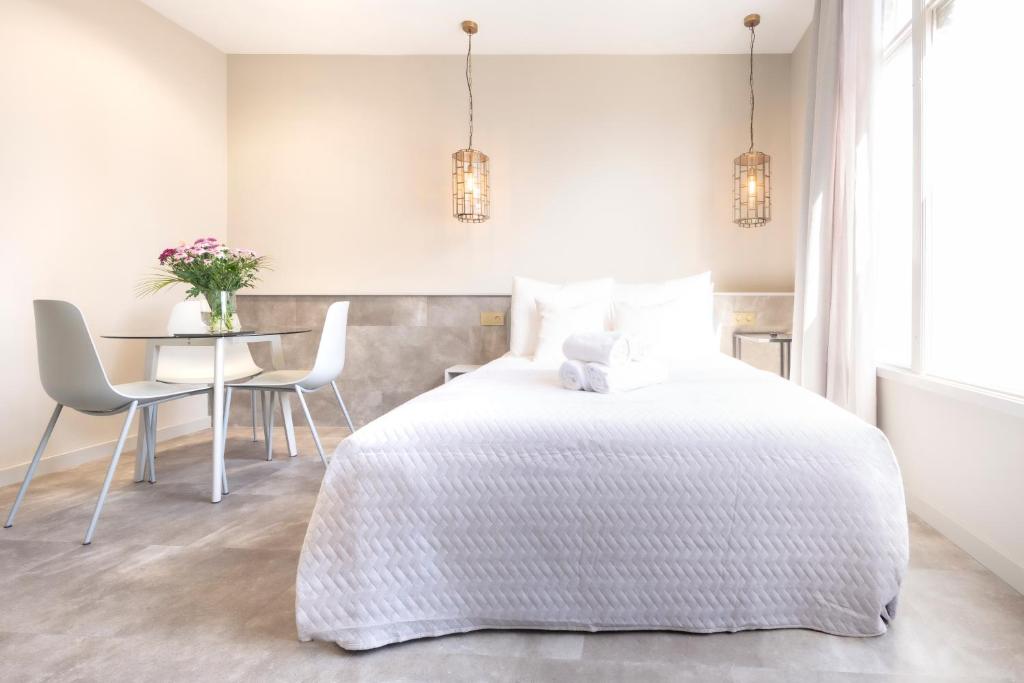 1 dormitorio con 1 cama, mesa y sillas en Luxurious Penthouse Newly Build just 7-Minutes from Rotterdam CS City app3, en Schiedam