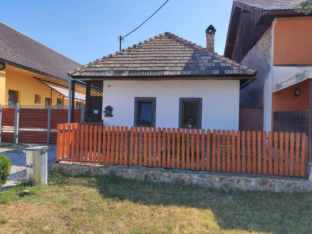 una pequeña casa blanca con una valla de madera en Domcek Lutila 54, en Lutila