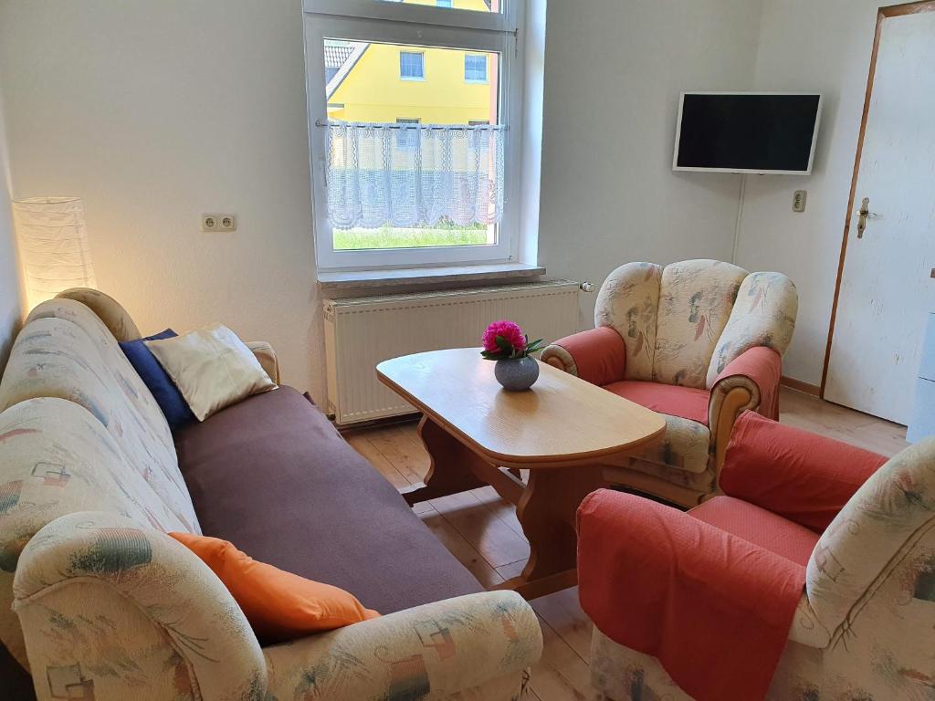 - un salon avec deux canapés et une table dans l'établissement Ferienwohnung Ost - Alte Schule Sachswitz, à Greiz