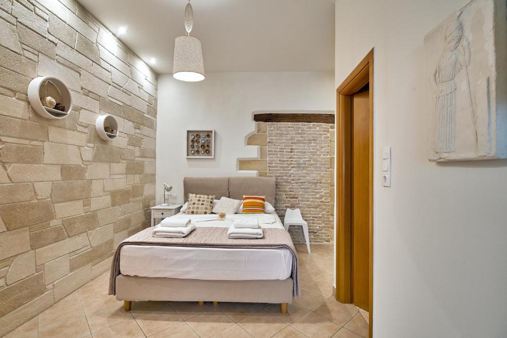 ein Schlafzimmer mit einem Bett und einer Ziegelwand in der Unterkunft Semeli Apartment in Kissamos