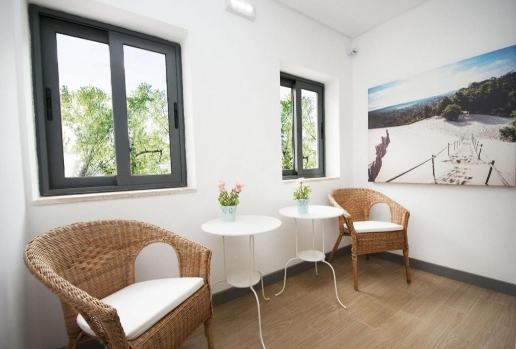 a room with two chairs and a table and two windows at In Downtown - Villa Serenity in Albufeira