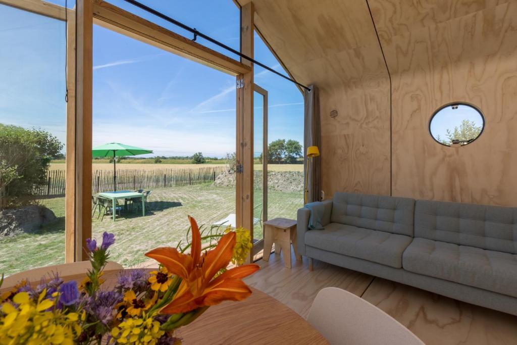 a living room with a couch and a table at Wikkelhouse, Kon. Emmaweg 6 Vrouwenpolder in Vrouwenpolder