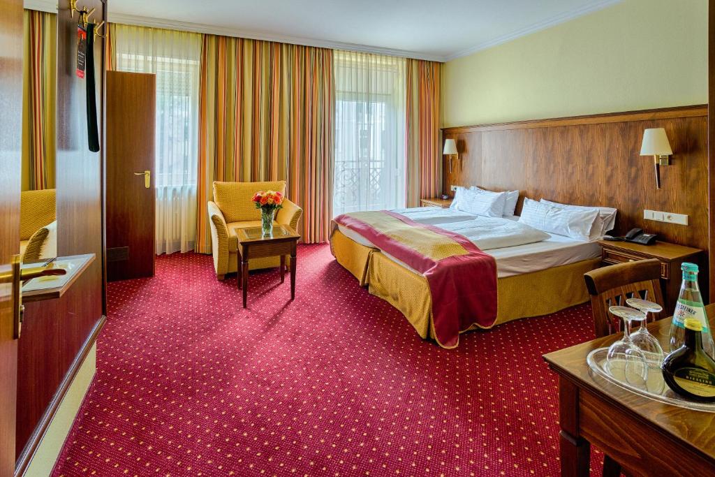 a hotel room with a large bed and a desk at Hotel Römerhof in Baden-Baden