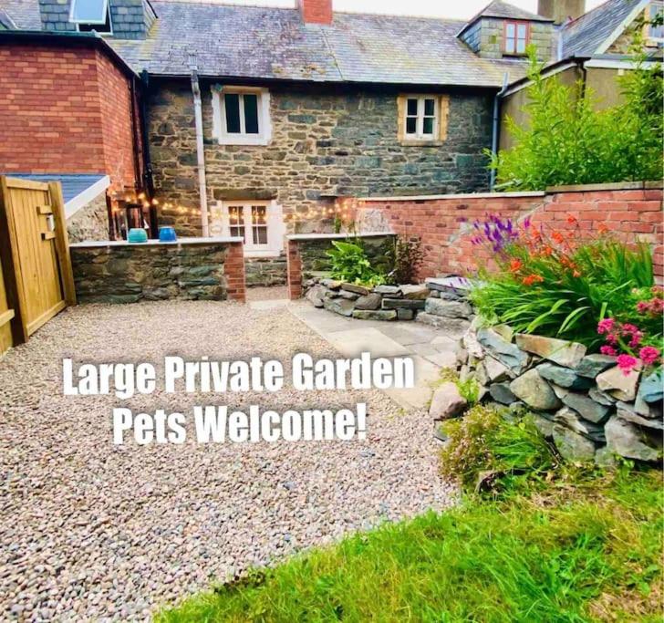 un patio trasero con una casa de piedra con un patio de piedra en The Mynach Annex en Barmouth