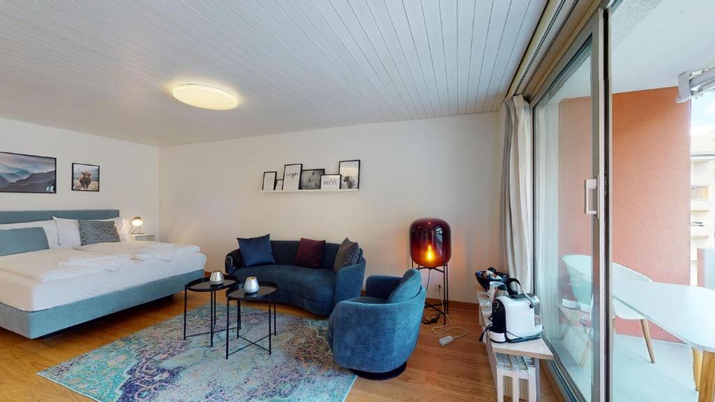 ein Schlafzimmer mit einem Bett und einem blauen Stuhl in der Unterkunft Abitaziun Skyline 414 - St Moritz "LOGA ELEGANCE APARTMENT" in St. Moritz