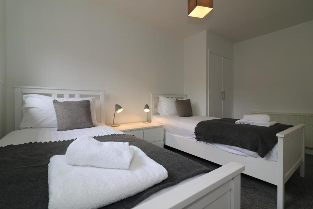 a bedroom with two beds with towels on them at Signature - Belhaven House in Hamilton