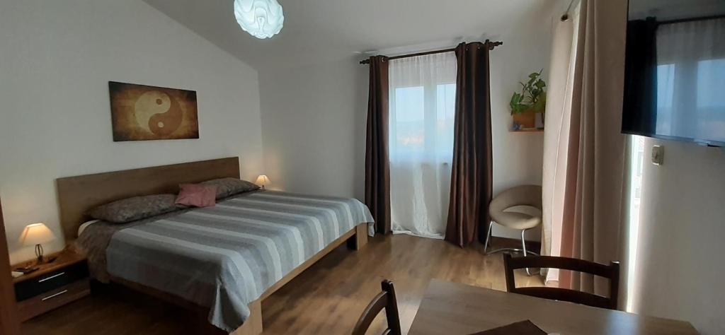een slaapkamer met een bed en een tafel en een televisie bij Apartments ALTO in Rovinj