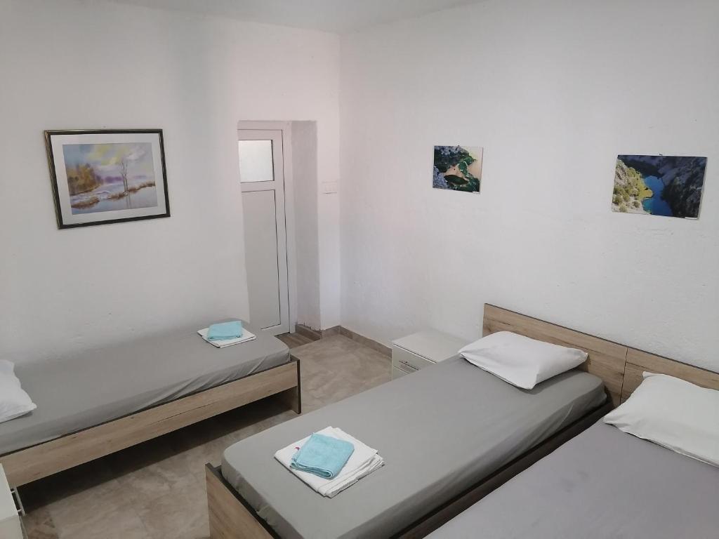 Cette chambre comprend 2 lits et une fenêtre. dans l'établissement Apartman Milan, à Obrovac