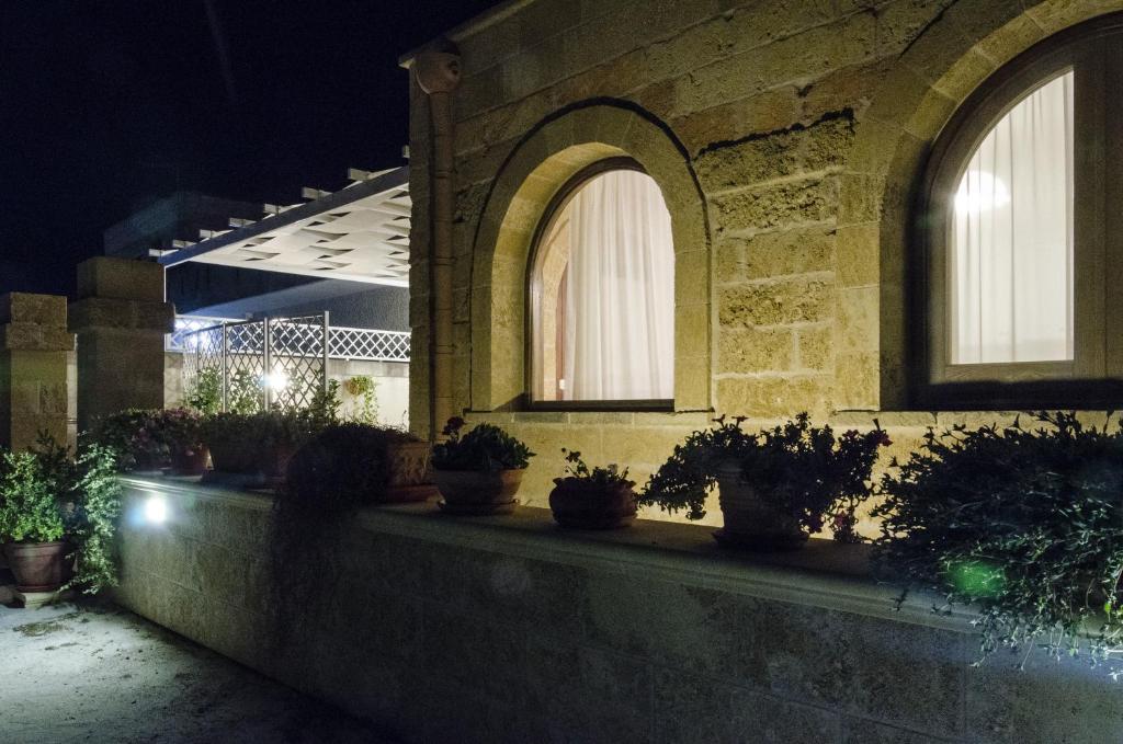 un edificio con piante in vaso su un cornicione di notte di Stella Dei Campi a Sternatia