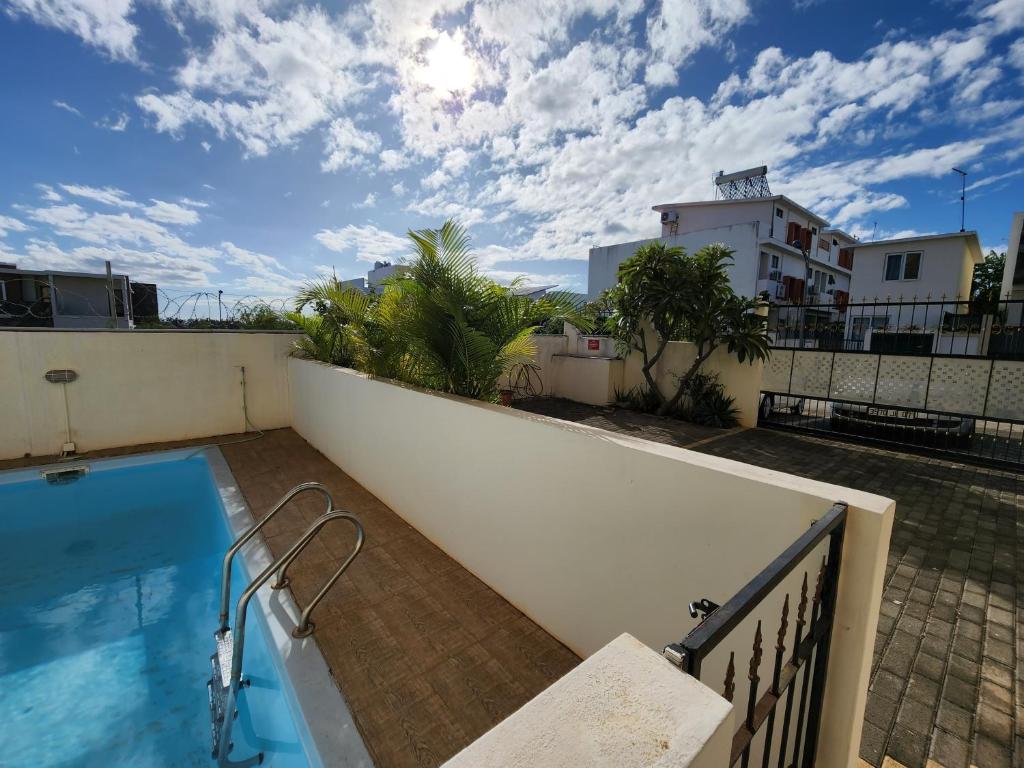 een uitzicht vanaf het balkon van een huis met een zwembad bij Sunsetview Beach Apartment in Palmyre