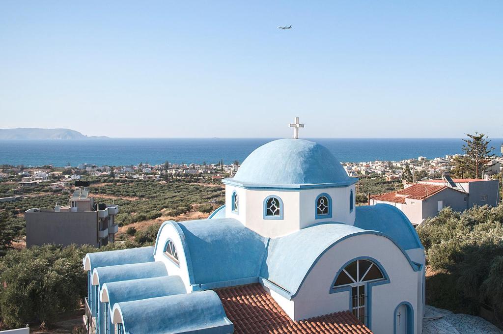a blue and white church on top of a hill at Adorable Country House with sea & church view! in Kokkini Khanion