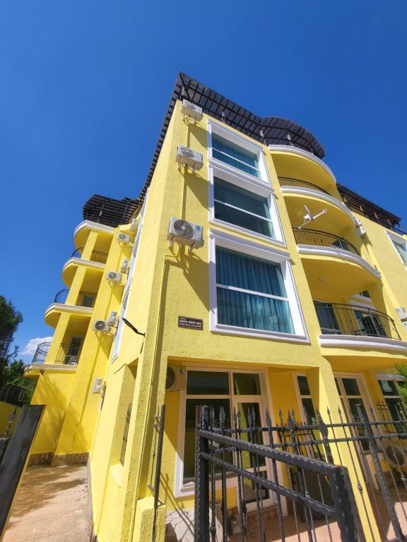 un bâtiment jaune avec des fenêtres latérales dans l'établissement Lucky Sun Kranevo Apartments, à Kranevo