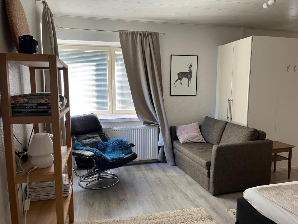 ein Wohnzimmer mit einem Sofa und einem Stuhl in der Unterkunft Little house with sauna in Lahti