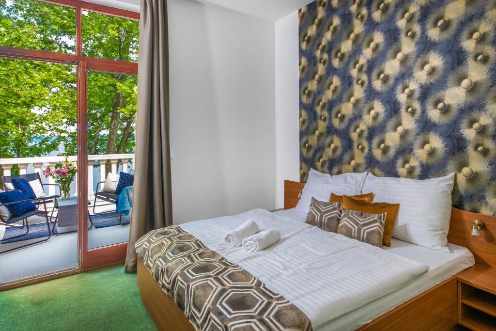 ein Schlafzimmer mit einem Bett und einem Balkon in der Unterkunft Hotel Anna Villa in Balatonföldvár
