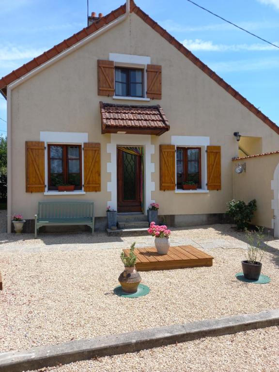 a house with a bench in front of it at Chambres d' Hotes a Benaize in Coulonges