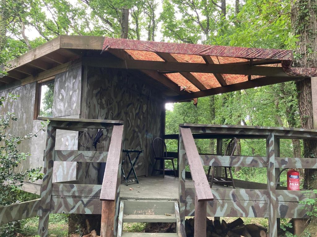 a wooden structure with a roof on top of it at Unique off Grid Tree-House Stay in oak woodland in Longhope