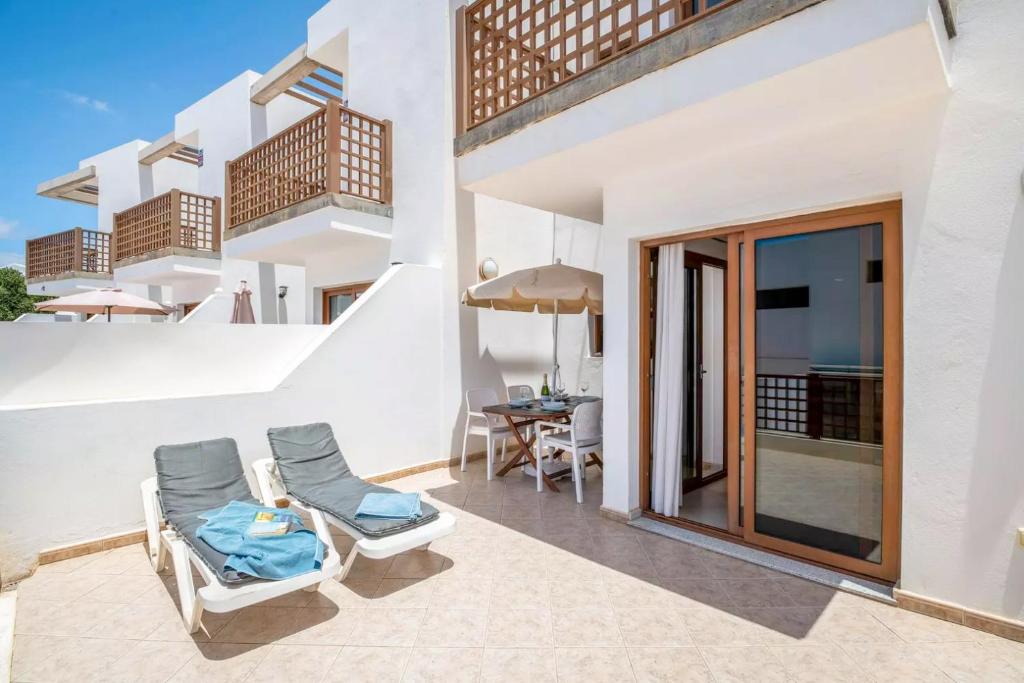 an outdoor patio with chairs and a table at Modern Duplex in Puerto del Carmen in Tías