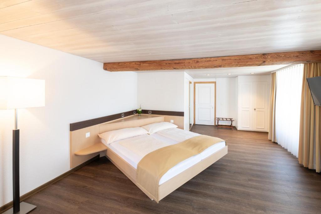 ein Schlafzimmer mit einem großen Bett und einer Holzdecke in der Unterkunft Hotel zum goldenen Kreuz in Frauenfeld