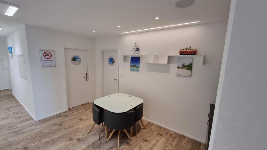 ein weißes Zimmer mit einem Tisch und 2 Stühlen in der Unterkunft BeachIN - Sport, Events, Hotel, Restaurant, Bar in Ins