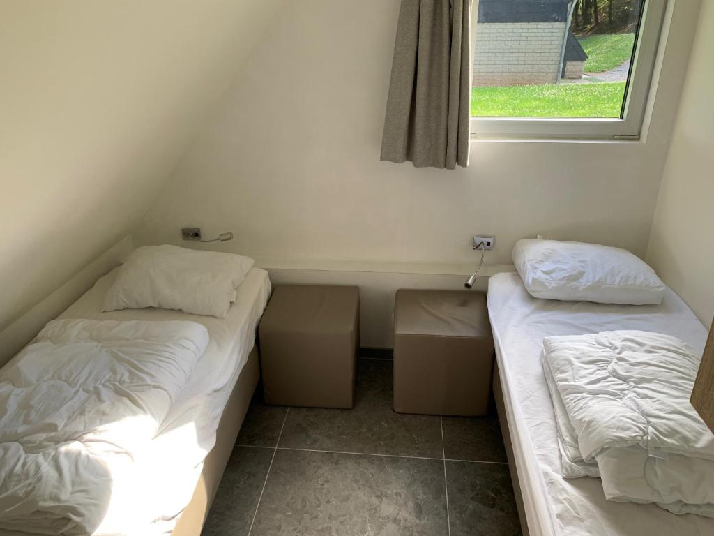 2 Betten in einem kleinen Zimmer mit Fenster in der Unterkunft Maison Napoleon in Malmedy