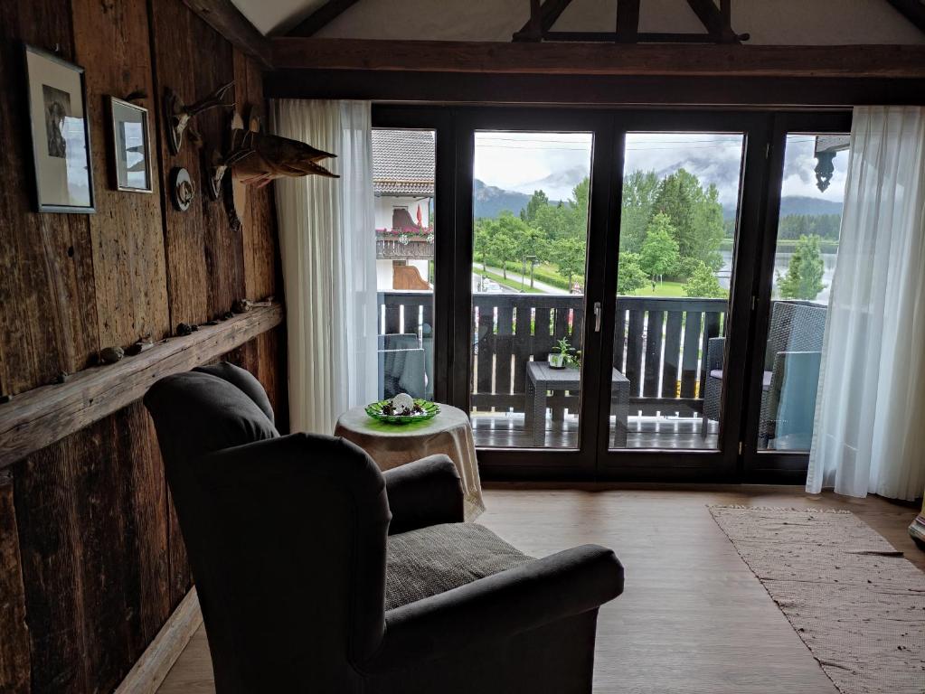 salon z kanapą i balkonem w obiekcie Direkt am Hopfensee- Ferienwohnung w Füssen