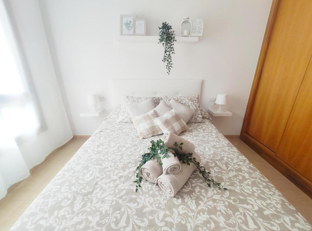 a white bed with two pillows and areath on it at Almar Carril in Vilagarcia de Arousa