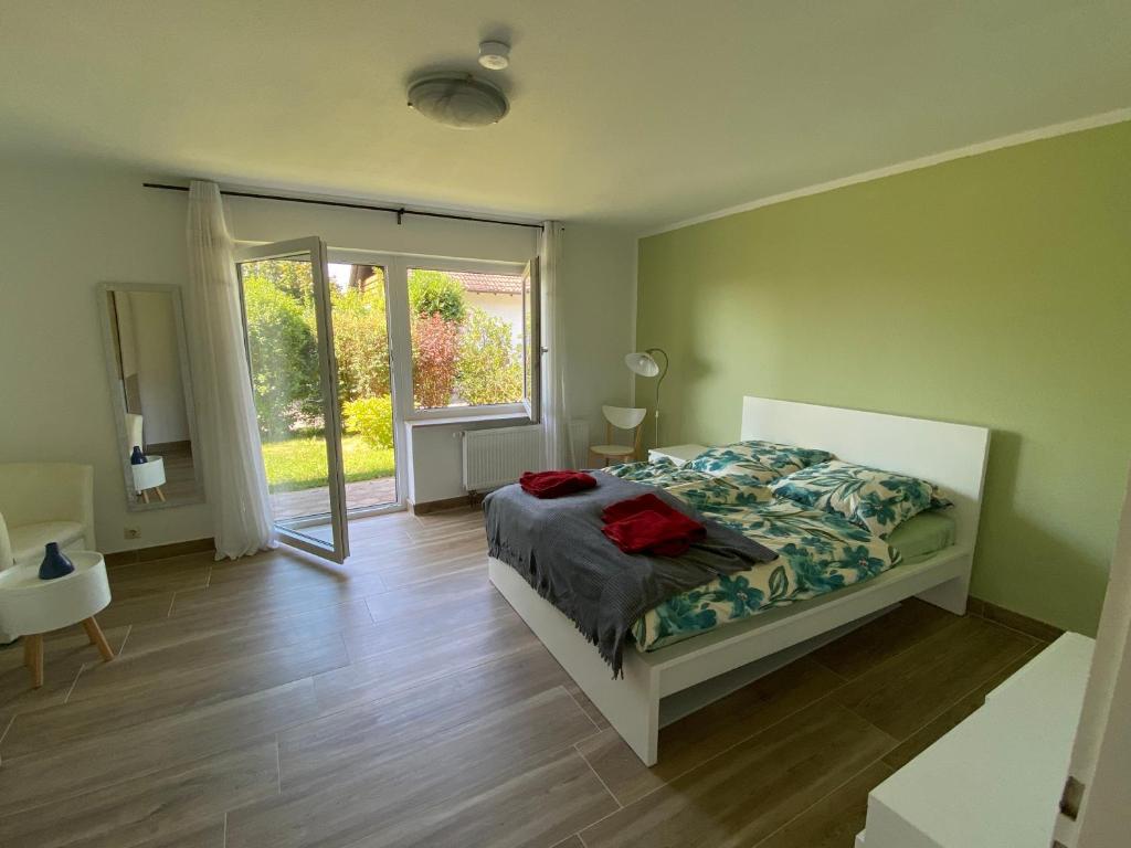 Schlafzimmer mit einem Bett und einer Glasschiebetür in der Unterkunft Ferienwohnung Löwenzahn in Fischingen