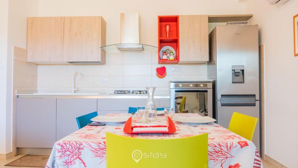 kuchnia ze stołem, krzesłami i lodówką w obiekcie Cozy Apartment Alghero w mieście Alghero